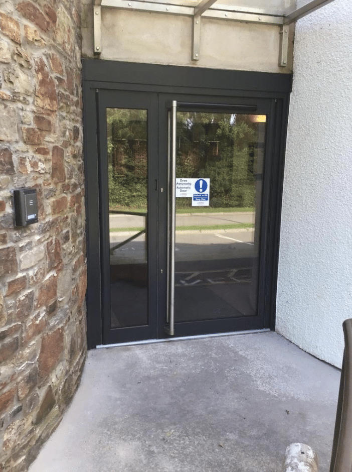 Grey automatic swing door with full height handle
