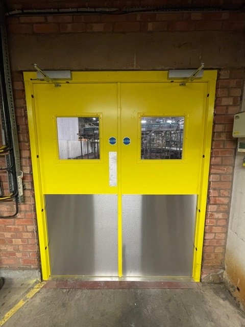 Steel Doors for Commercial Buildings. Steel doors in yellow - Double with Bison panels and door closers.