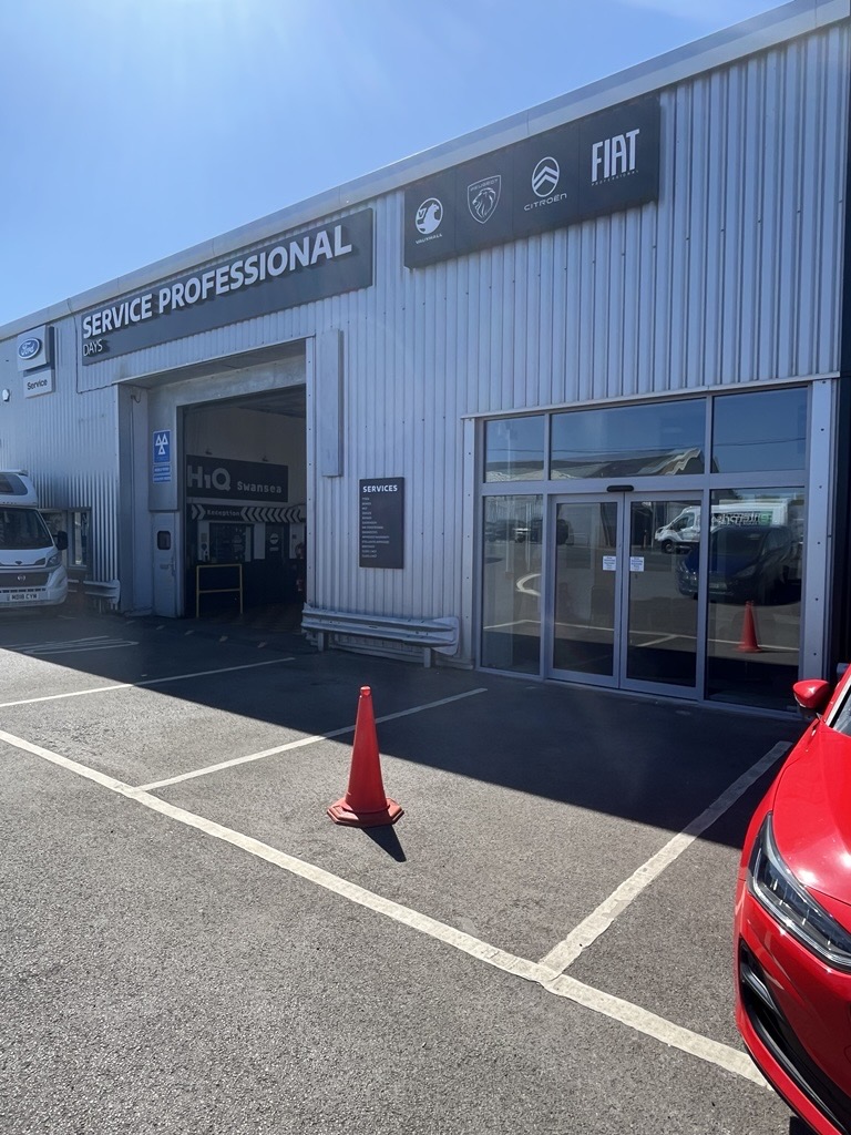 Automotive dealership shopfront installation showing front entrance with aluminium shopfront and automatic sliding doors